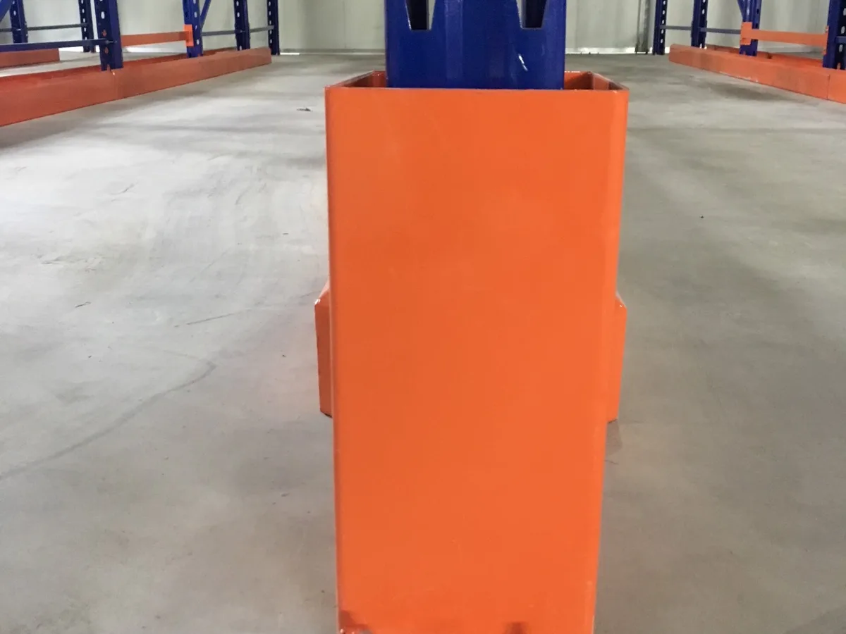 Chân bảo vệ màu cam bọc chân khung đứng tại lối vào làn kệ Drive-in
