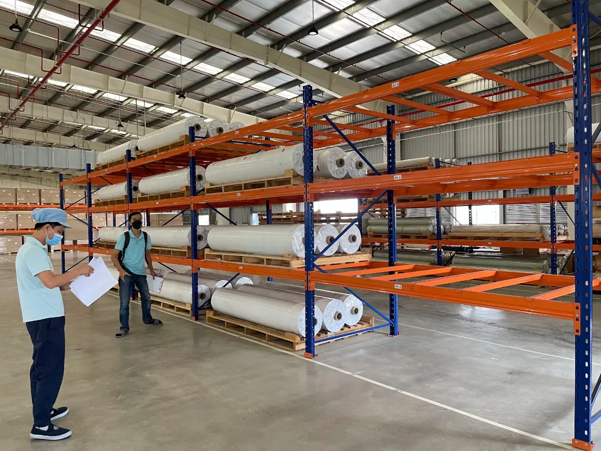 Kệ Selective 6 Kệ Selective lưu trữ cuộn vật liệu trên pallet trong nhà máy, nhân viên kiểm tra hàng